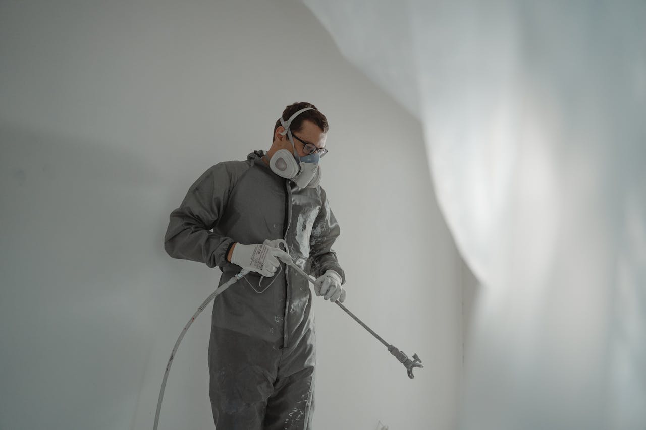 creative Person in protective gear painting a wall, showcasing house renovation work.